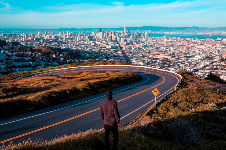 Man standing at a curved road